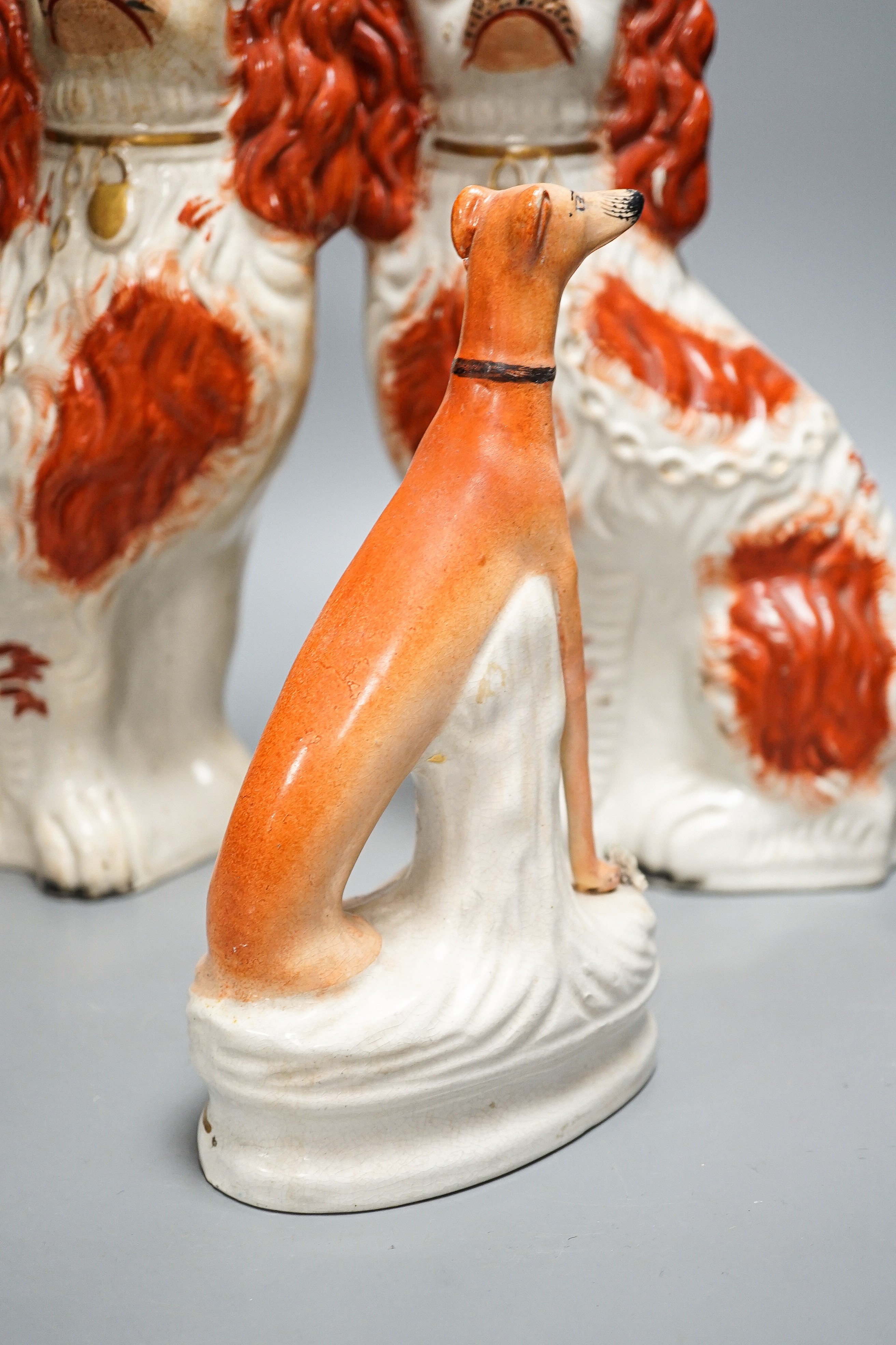 A pair of Victorian Staffordshire Spaniel chimney dogs and a greyhound, chimney dogs 31 cms high.